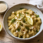 Bowl of fluffy cooked quinoa topped with parsley, lemon, and toasted almonds
